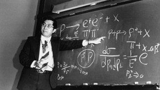 Physicist Samuel Ting points at equations on a blackboard that describe the subatomic particle J/psi.